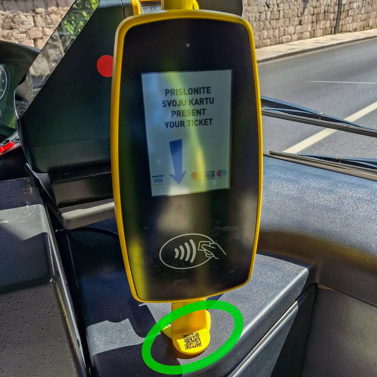Close-up of the digital NFC ticket validator terminal located next to the driver onboard Libertas buses