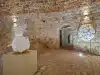 Stone corridor leading to a side chamber inside Bokar Fortress with a small horse sculpture visible ahead