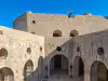 Elevated view from a mid-level terrace of Fort Lovrijenac showing the courtyard, upper levels, and a distant cannon