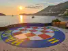 View across the Hotel Belvedere amphitheater toward Dubrovnik Old Town with a historic galleon ship at sea