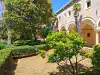 Courtyard garden showing the historic stone cloister arches at the Benedictine monastery on Lokrum Island