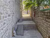 Stone pathway on Margarita Street beside the Dubrovnik City Walls with the courtyard near St. Margarita Bastion visible