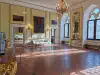 Interior view of an exhibition room displaying historical paintings and antique tables inside the Rector's Palace