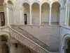 View from the upper gallery showing the stone columns and a side profile of the staircase inside the Rector's Palace
