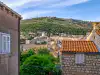 Panoramic wide view from the Rupe Museum area looking toward the Franciscan Monastery bell tower and Minčeta Tower against the backdrop of Srđ Mountain
