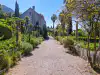 Coarse sandy pathway in Trsteno Arboretum main gardens lined with prominent stone pillars