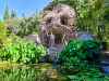 Side angle of Poseidon fountain statue and dense water lily greenery in Trsteno Arboretum