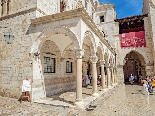 Front of Sponza Palace in Dubrovnik with its elegant stone loggia beneath the balcony, a Renaissance landmark on Old Town history walking tours