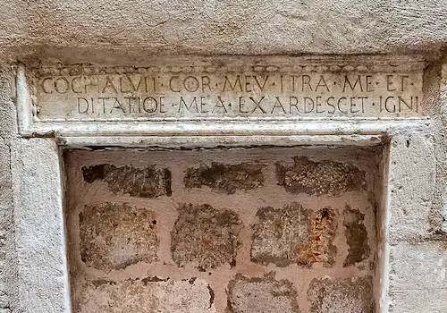 Stone entrance of Dubrovnik’s former orphanage with a carved Latin inscription, a moving reminder of social life in the Republic of Ragusa and a hidden gem on Old Town walking tours